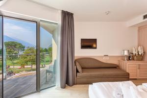 加尔达湖滨贝拉丽瓦酒店的一间卧室设有一张床和一个滑动玻璃门
