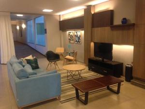 伊通比亚拉Orion Hotel的客厅配有蓝色的沙发和电视