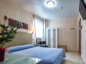 穆尔西亚莱加斯皮酒店的一间卧室配有蓝色的床和玻璃桌