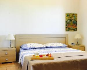 普尔萨诺Villa Lido Silvana Marina di Pulsano的一间卧室配有一张床,上面有水果盘
