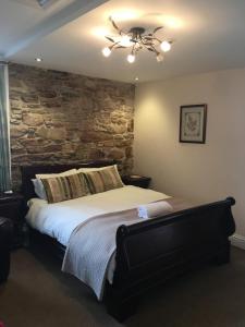因弗戈登The Ship Inn的一间卧室设有一张带石墙的大床