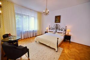 德瓦Casa Negustorului的卧室配有一张床和一张桌子及椅子