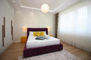 萨拉热窝Radiceva Apartment的一间卧室配有带白色床单和黄色枕头的床。