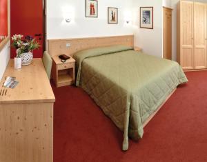 佩尔吉内瓦尔苏加纳罗通达酒店的一间卧室配有绿色的床和一张木桌