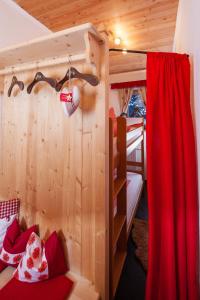 菲根Chalet Tyrol的一间卧室配有双层床和红色窗帘
