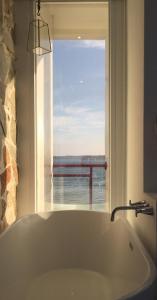 南湾迷路小章魚小旅館的带窗户的浴室设有大浴缸