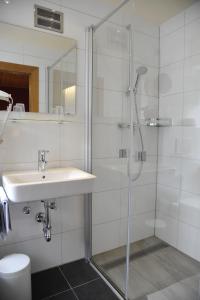 伦韦格Hotel-Landgasthof Katschtalerhof的一间带玻璃淋浴和水槽的浴室