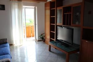 科雷多Appartamento Widmann的客厅配有电视和蓝色沙发。