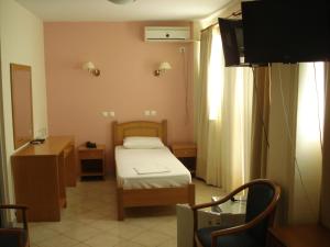 雅典赛贝勒住宿酒店的小房间设有一张床和一台电视机