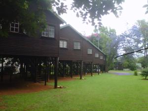 萨比Travel Lodge Sabie的一座大型木屋,前面有一个草地庭院