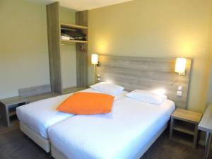 欧赖Kyriad Auray的卧室配有白色的床和橙色枕头
