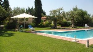 孔韦尔萨诺Casa vacanze Leralora的一个带遮阳伞的庭院内的游泳池
