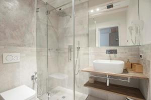 阿科Le Scuderie B&B的一间带水槽和玻璃淋浴的浴室