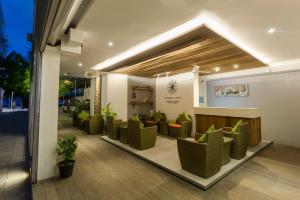 胡鲁马累呼尔胡维拉海滩椰子树酒店的大楼内带绿色椅子的等候室