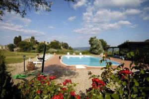 MontecastelliFarmhouse Tuscany的一个游泳池,周围的人坐在游泳池周围