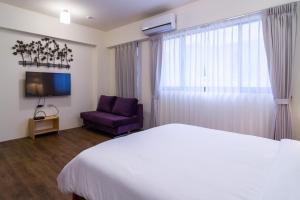 头城温蒂的家头城A馆的卧室配有白色的床和紫色椅子