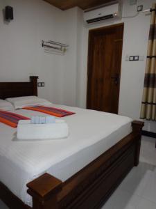 阿努拉德普勒拉雅拉塔度假酒店的一间卧室配有一张带白色床单的大床