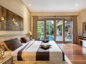 坎古新奇巴厘岛别墅住宿加早餐旅馆的一间卧室设有一张大床和一个滑动玻璃门