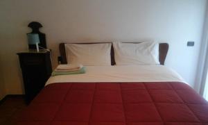 特拉尼Suite210的红色和白色的床,配有白色床单和枕头