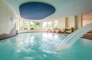HeimbuchenthalLandhotel Heimathenhof的一座游泳池,在酒店的房间内设有一个喷泉