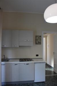 雷焦卡拉布里亚La Casa di Aurora的白色的厨房配有白色橱柜和水槽