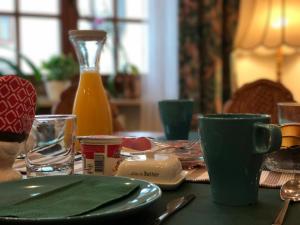 巴特维尔德巴德蒂洛旅馆的一张带绿盘和杯子的桌子以及一瓶橙汁