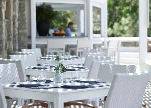 胡拉吉亚圣马可别墅酒店的白色的桌椅,带盘子和玻璃杯