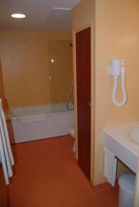 巴勒迪克贝尔特兰德酒店的带浴缸、卫生间和盥洗盆的浴室