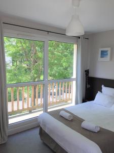 多维尔多维尔南甜蜜之家公寓式酒店的一间卧室设有一张床和一个大窗户