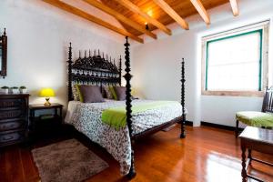 里斯本Atelier - House in Belém的一间卧室设有一张四柱床和一个窗户。