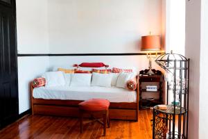 里斯本Atelier - House in Belém的卧室配有1张床、1张桌子和1把椅子