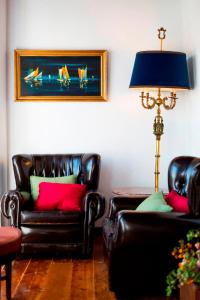 里斯本Atelier - House in Belém的客厅配有2把皮椅和1盏灯
