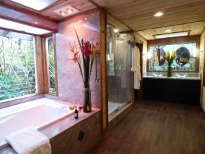 沃尔卡诺莲花园小屋旅馆的带浴缸和花瓶的浴室