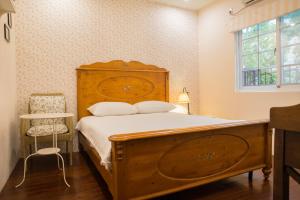 花莲市马略卡天空的一间卧室设有一张木床和一个窗户。