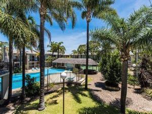 曼哲拉曼德拉公寓及汽车旅馆的一个带游泳池和棕榈树的度假村