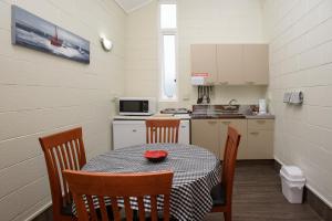 凯塔亚考里小屋汽车旅馆的一个带桌椅和桌子的小厨房和一间厨房