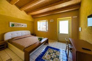 锡拉库扎Hotel Casale Milocca的一间卧室配有一张床、一张书桌和一个窗户。
