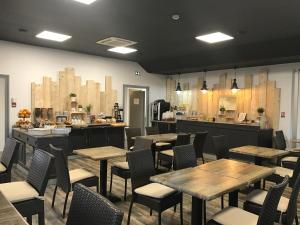 卡斯特尔库里埃尔Kyriad Direct Agen的餐厅设有木桌、椅子和柜台