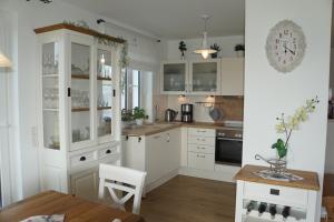 伯尔格伦德-雷特维施Reethaus Casa Baltica的厨房配有白色橱柜和木桌