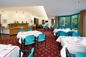 莱尔特蒙大拿特林德勒特酒店的用餐室配有白色的桌子和蓝色的椅子