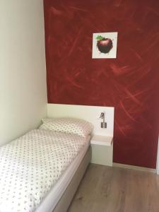 Prato特恩西亚住宿加早餐旅馆的一间小卧室,配有一张床和红色的墙壁
