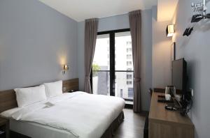 台中市台中逢甲米乐旅店的酒店客房设有一张床和一个大窗户