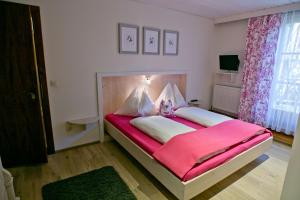 蓬高地区埃本菲林霍夫奥内加特公寓的一间卧室配有一张带粉色毯子的大床