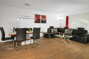 采尔马特索恩马特之家公寓的客厅配有黑色沙发和桌子