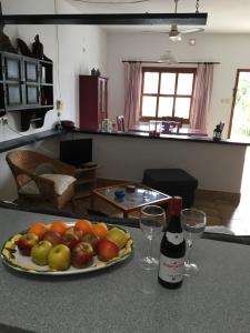 奥尔索拉Apartamentos Los Vientos (Apto 1)的柜台上的一盘水果和一瓶葡萄酒