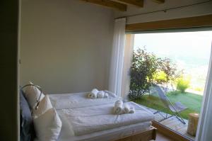 卡尔多纳佐Agriturismo Verdecrudo的一间卧室设有两张床和大窗户