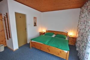 埃本塞Pension Sybille的一间卧室配有一张带绿色床单的木床。