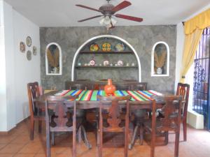 卡特马科Posada Bugambilias的用餐室配有桌椅和吊扇