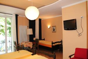 卡斯拉诺欧斯特里亚巴特罗旅馆的一间设有床铺和墙上电视的房间