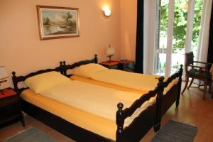 卡斯拉诺欧斯特里亚巴特罗旅馆的卧室设有两张单人床和窗户。